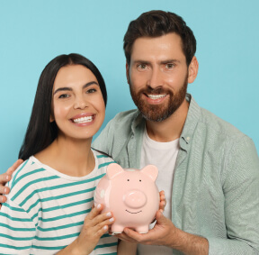 Pareja ahorrando en una alcancía sonriendo