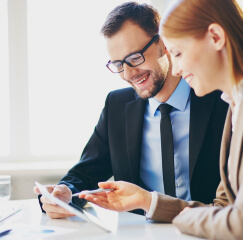 Dos compañeros de trabajo revisando unos documentos en el celular